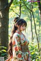 A woman in a kimono standing in the woods.