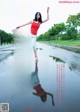 A woman in a red top and white skirt standing in the middle of a road.